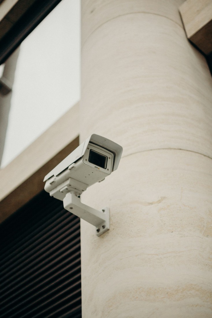 Caméra de vidéosurveillance blanche installée en extérieur sur une façade